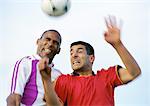 Two players competing for the ball during a soccer match, blurred, portrait.