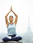 Paris, France, woman sitting in yoga position, Eiffel tower in background