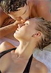 Couple lying down, man kissing woman's forehead, close-up