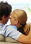 Couple sitting on sofa, rear view, close-up