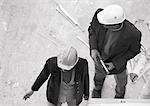 Two people wearing hard hats, elevated view, b&w