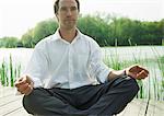 Businessman in lotus position, outdoors