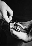 Man taking the pin out of grenade, close-up, b&w