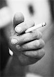 Hand holding cigarette, close-up, b&w