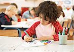 Child sitting at table, drawing, head and shoulders