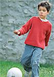 Child playing soccer, full length, close-up