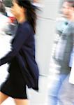 Businesswoman walking, side view, blurred