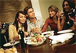 Group of young people around table, drinking