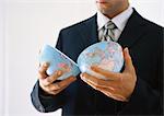Businessman holding globe halves