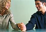 Couple holding hands at table, lovingly smiling at each other