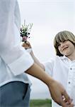 Boy handing woman bouquet of wildflowers