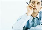 Man holding pen near face, looking up