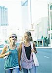 Two teenage girls walking in city