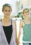 Two teenage girls walking in city