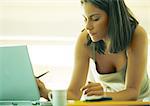 Woman leaning on table using laptop