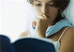 Young woman reading book, close-up