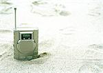 Radio sticking out of sand on beach