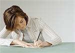 Young woman with notebook, erasing