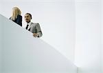 Businessman and businesswoman standing face to face, low angle view