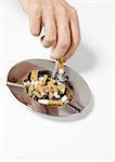 Hand putting out cigarette in ashtray