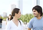 Young couple smiling at each other in urban park