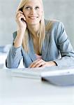 Femme d'affaires à l'aide d'un téléphone cellulaire, souriant