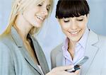 Two businesswomen looking at cell phone