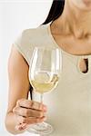 Woman holding glass of white wine, cropped view