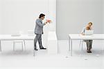 Supervisor shouting at employee with megaphone, woman sitting with laptop, surrounded by crumpled paper