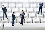 Miniature businessmen standing face to face on computer keyboard