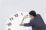 Businessman pushing back hands of clock