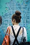 Frauen suchen bei großen Landkarte auf Wand, Rückansicht