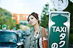 Young female waiting at taxi stand