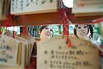 Les jeunes femelles regardant ema japonais traditionnels voeux au temple shintoïste