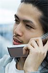 Young male using cell phone, looking away