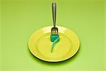 Food concept, fork with rolled up gummy candy strip on plate, resembling noodle
