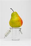 Food concept, pear on top of small glass jar
