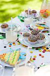 Geeiste Cookies und Cupcakes auf Tisch mit luftschlangen und Süßigkeiten verziert