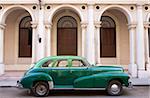Classic green American car parked outside The National Ballet School, Havana, Cuba, West Indies, Central America