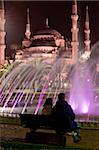 Fontaines colorées pendant la nuit dans le parc de Sultan Ahmet, un lieu de rassemblement favori pour les habitants et les touristes, en regardant vers la mosquée bleue, Istanbul, Turquie, Europe