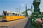 Yellow tram on The Liberty Bridge (Szabadsag hid), over the Rver Danube, Vamhaz Korut street, Budapest, Hungary, Europe