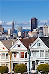 The famous Painted Ladies, well maintained old Victorian houses on Alamo Square, with the skyscrapers of the Financial district beyond, San Francisco, California, United States of America, North America