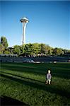 Enfant en bas âge marche sur pelouse vers Space Needle à Seattle Center, Seattle, état de Washington, États-Unis d'Amérique, Amérique du Nord