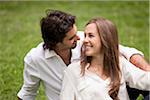 Close-up Portrait of Young Couple Sitting on Grass in Park