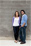 Portrait of Young Couple Standing in front of Stone Wall