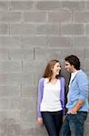 Young Couple Standing in front of Stone Wall