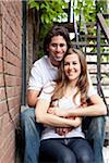 Portrait of Young Couple Sitting on Fire Escape, Toronto, Ontario, Canada