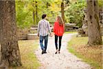 Backview of Young Couple Walking through Park in Autumn, Ontario, Canada