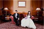 Bride and Groom Sitting on Loveseat