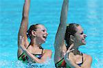 Synchronized Swimmers Performing in Swimming Pool